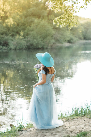 woman in white dress with flowers in her handsの写真素材