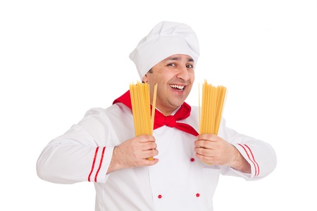 smiling cook man wearing white uniform holding raw macaroni in the studio over white backgroundの写真素材