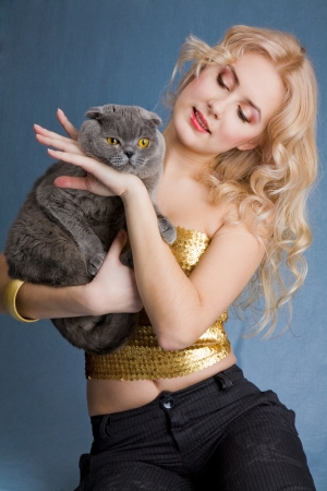 Beautiful blonde smiling woman with grey catの写真素材