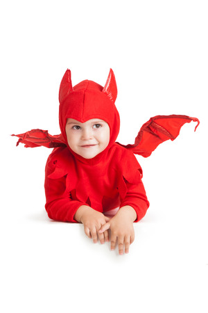 smiling little boy in red devil costume over white backgroundの写真素材