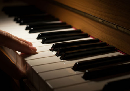 Woman hand playing music on a digital piano, close up view of finger pressing piano key at home. Instrumental player finger on black note. World Music Day.の素材