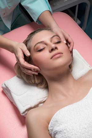 Cosmetician doing receiving facial massageの写真素材