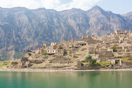 An abandoned old village on the shore of a lake in the mountains. Irganayskoe reservoir, Dagestan Russiaの写真素材
