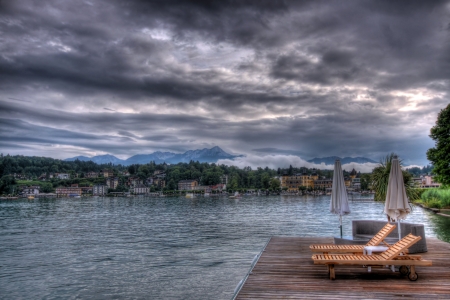 some deck chairs next to waterの写真素材
