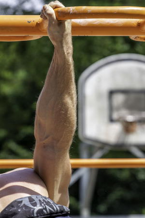 muscular arm of a man doing excercise on the street  Unrecognizable 