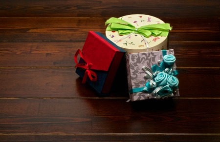 Three presents on the dark brown wooden table