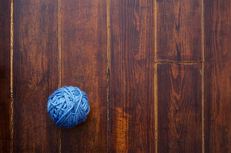 Blue skein over wooden brown striped tableの写真素材