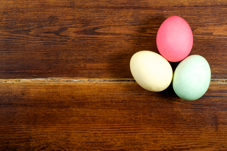 Three easter eggs over wooden background with cardの写真素材