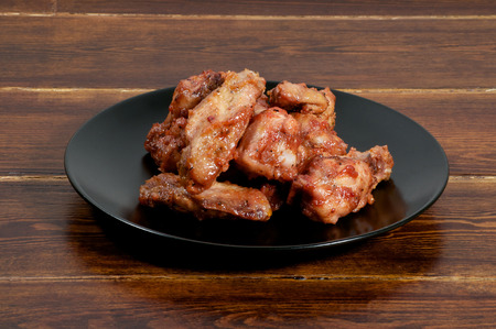 Glazed chicken barbecue wings over wooden backgroundの写真素材