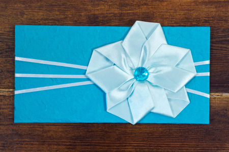 Blue envelope with bow over wooden backgroundの写真素材