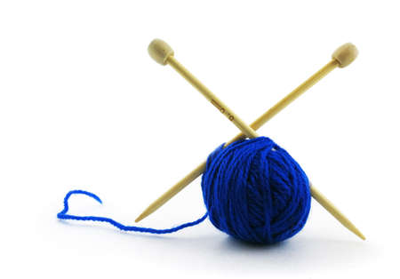 A blue ball of knitting thread with needles stuck in it on an isolated white background.の写真素材