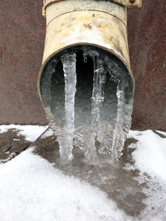 Dripping Icicles on the sewer pipeの写真素材