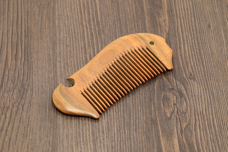 Green sandalwood comb on a wood backgroundの写真素材