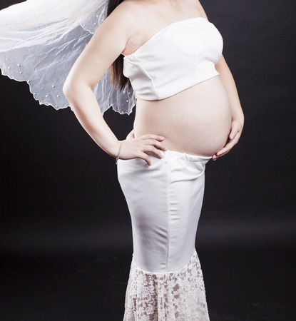 A pregnant mother in black backgroundの写真素材