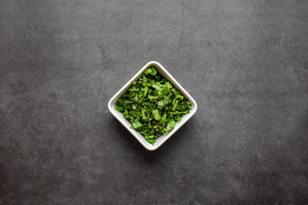 Chopped Fresh Coriander leaves in white plate on white background. top view.