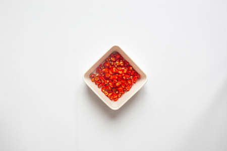 Chopped Chili peppers in white plate on white background. top view.の写真素材