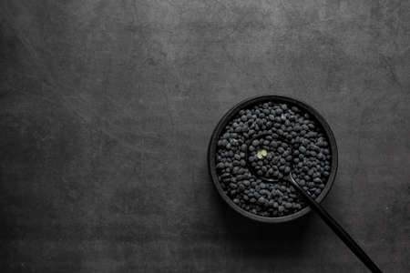 Black beans in bowl on dark grey background.の写真素材