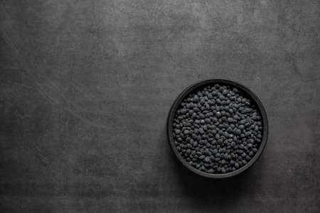 Black beans in bowl on dark grey background.の写真素材