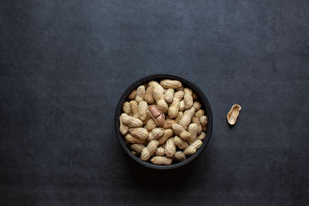 peanuts in bowl on dark grey backgroundの写真素材