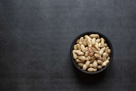 peanuts in bowl on dark grey backgroundの写真素材