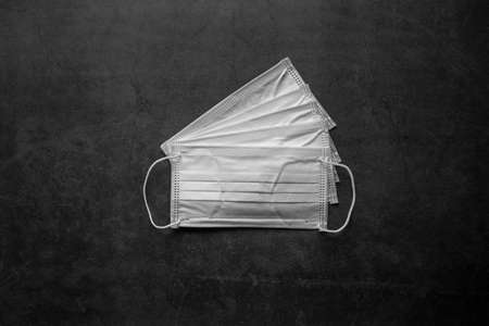 Surgical mask with rubber ear straps. Typical 3-ply surgical mask to cover the mouth and nose. Procedure mask from bacteria. Protection concept.の写真素材