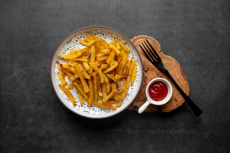 French fries on dark table, top view