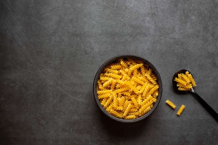 Spiral macaroni on dark grey background.の写真素材