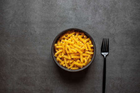 Spiral macaroni on dark grey background.の写真素材