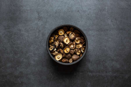 Dried Shiitake Mushrooms in bowl on dark grey background.の写真素材