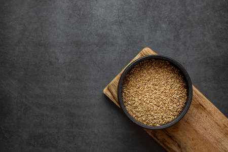 Oats rice in bowl on dark grey background.の写真素材