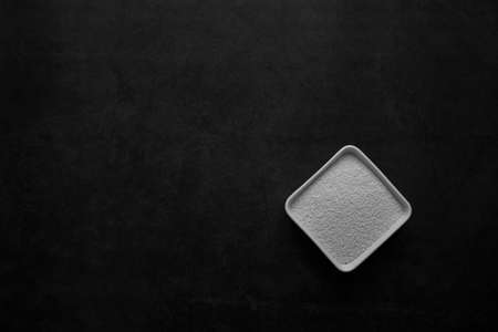 MSG in white dish on black background.Monosodium glutamateの写真素材