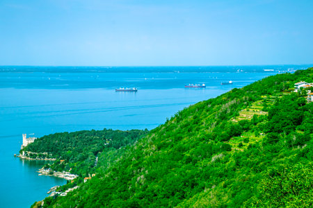 A majestic structure elegantly sits atop a high hill, majestically overlooking a tranquil and picturesque body of water belowの写真素材