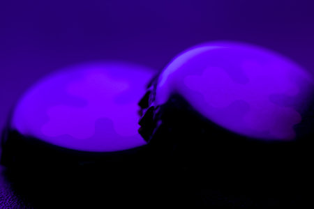 two A mysterious purple object is softly glowing in the dark surroundingsの写真素材
