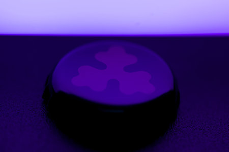 A mysterious purple object is softly glowing in the dark surroundingsの写真素材