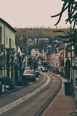 There is a narrow street that has a significant number of cars on itの写真素材