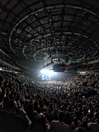 A large crowd of enthusiastic people enjoying a concert in a stadiumの写真素材