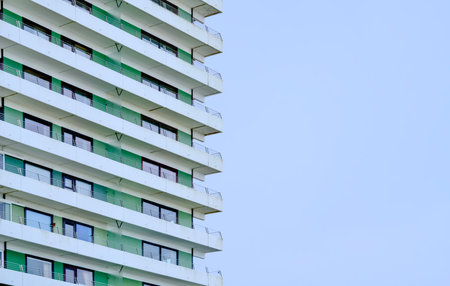 Apartment balcony rows with green accents and contemporary cladding, sustainable retrofit mood showcasing panel glazing, modularの写真素材