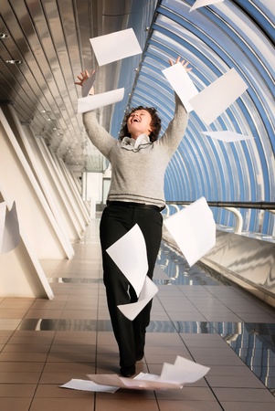 Young woman throwing up documentsの写真素材