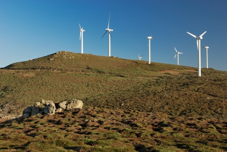 wind turbines over green mountains