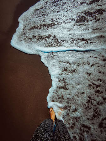 a wave comes in, as I stand and wait. copy space. top down view.の写真素材
