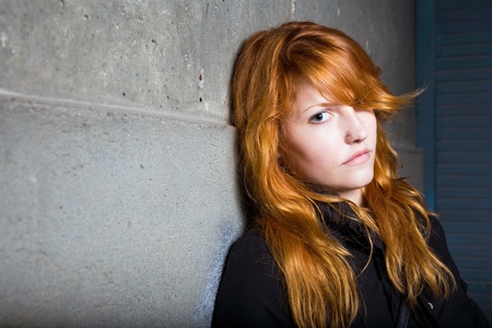 Scared and lonely, moody portrait of a beautiful fashoinable young redhead girl.の写真素材