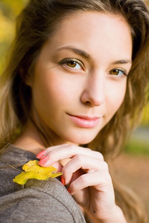 Beautiful young brunette posing in the park at fall.の写真素材