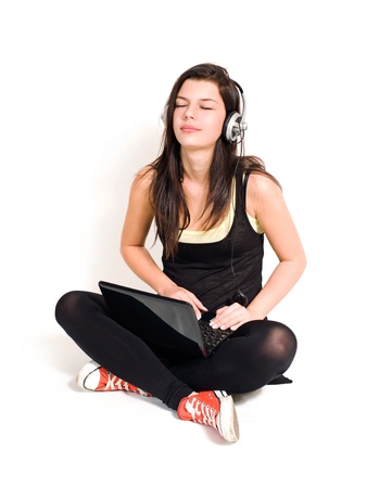 Gorgeous young brunette listening to music using small black laptop.の写真素材