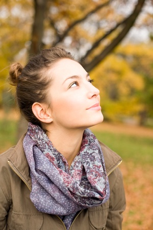 Beautiful young brunette posing in the park at fall.の写真素材