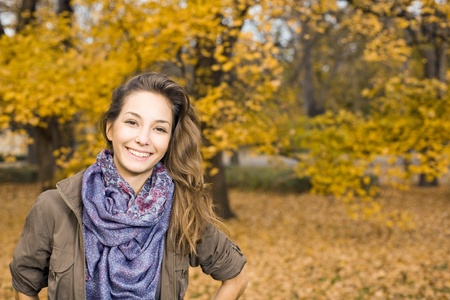 Beautiful young brunette posing in the park at fall.の写真素材