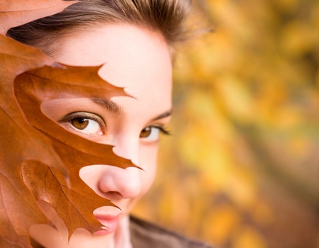 Gorgeous brunette peekaboo with fall leaves.