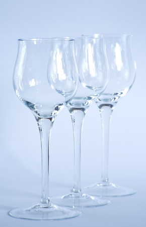 Arrangement of elegant wine glasses shot with cool blue filtering, focus on the front glass.の写真素材