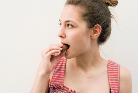 Portrait of a beautiful young brunette having chocolate snack.の写真素材