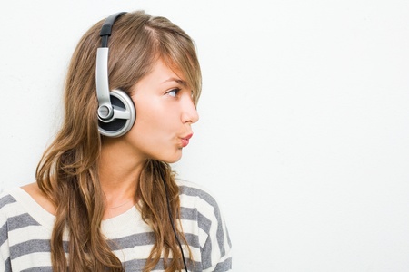 Beautiful young brunette listening to music with headphones..の写真素材