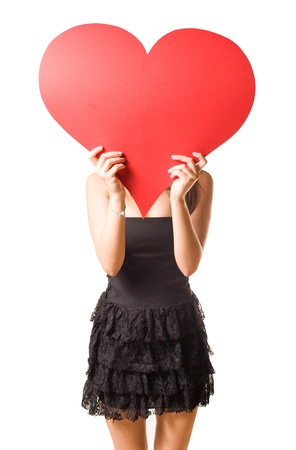 Gorgeous young brunette fooling around with large red heart shape, isolated on white background.の写真素材